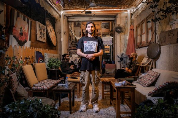 Hamza Abdelkader, 24, surrounded by art illustrations, books, musical instruments, in Sole Insight, the coffee shop he works in. In the background, his best friends and colleagues wonder about philosophical questions."We even gave the MK a mocking name, Umm Kamal, the mother of Kamal. When I wake up and its buzz is not there, for a moment I believe the war is over"